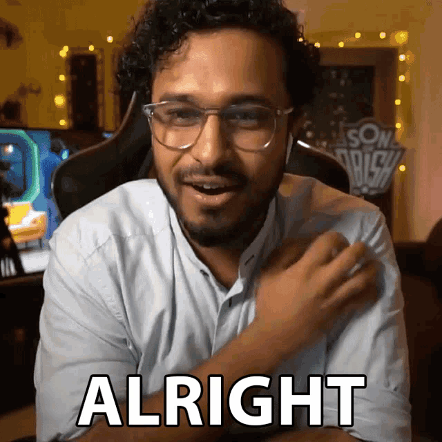 a man wearing glasses and a white shirt says " alright "