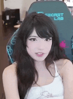 a girl with long black hair is sitting in a chair .