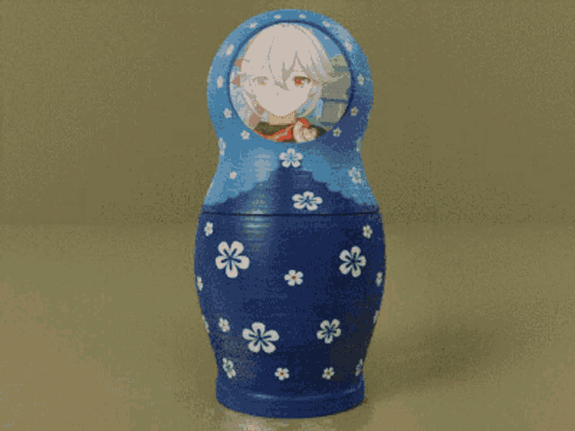 a blue green and orange matryoshka doll with a girl on it