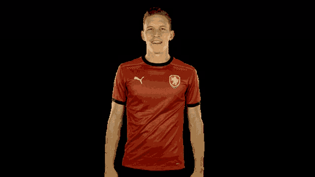 a man wearing a red shirt with the czech republic logo on it