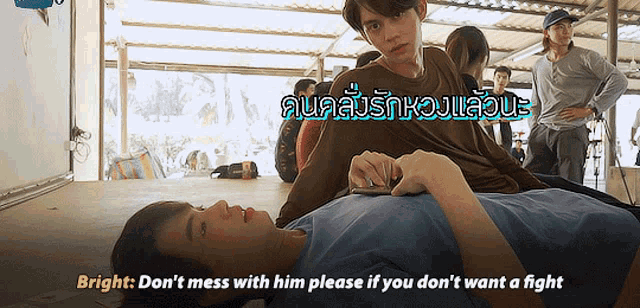 a man laying on another man 's chest with the words bright don 't mess with him
