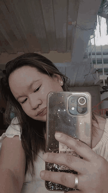 a woman is taking a selfie with her phone which has a clear case on it