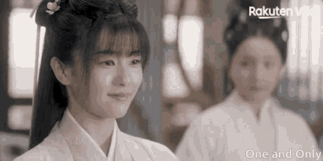 a woman in a kimono is smiling while standing next to a woman in a kimono .