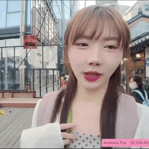 a girl is standing in front of a building with a sign that says australia trip on it