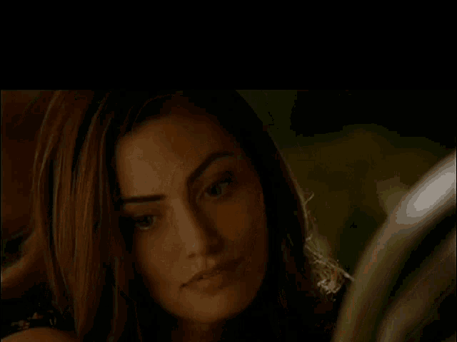a close up of a woman 's face in a dark room with a black background .