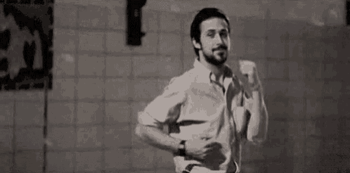 a man with a beard is standing in front of a tiled wall in a bathroom .