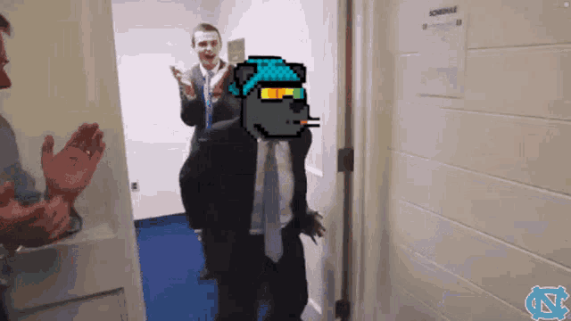 a man in a suit and tie is standing in a doorway with a schedule hanging on the wall behind him