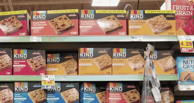 boxes of kind granola bars are displayed on a store shelf