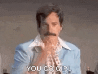 a man with a mustache is wearing a blue suit and a white shirt and is holding his hands together .