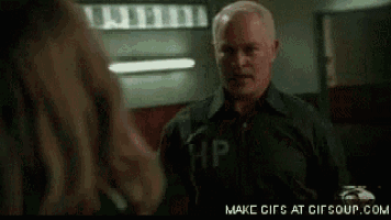 a man wearing a black shirt with the letter hp on it is talking to a woman .