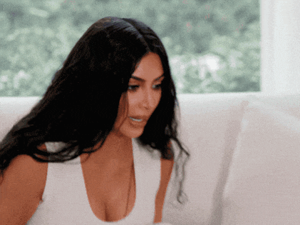 a woman with long black hair is sitting on a white couch
