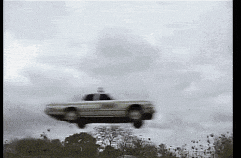 a police car is flying through the air .