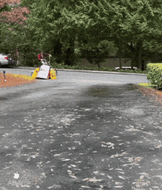 a person riding a bike down a road with an apple logo on the bottom right