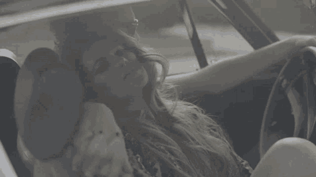 a man and a woman are sitting in a car .