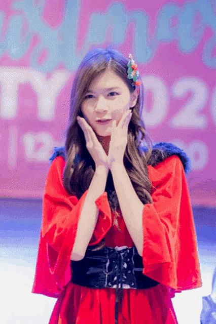 a girl in a red dress stands in front of a sign that says ' party 020 '
