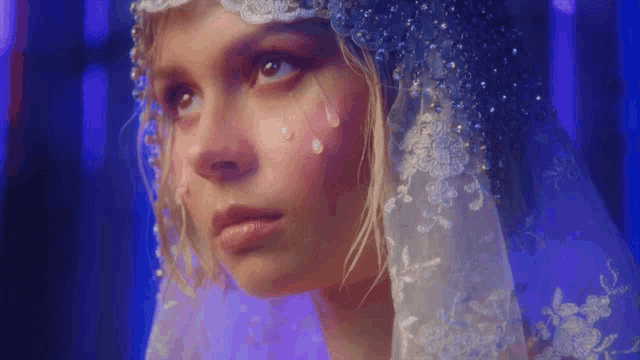 a close up of a woman wearing a veil with tears running down her face