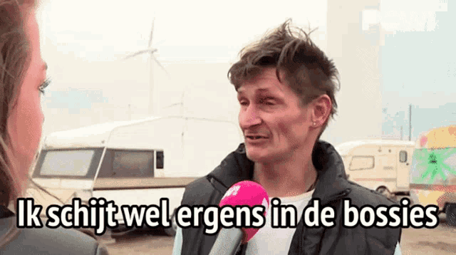 a man talking into a microphone with the words ik schijt wel ergens in de bossies written below him