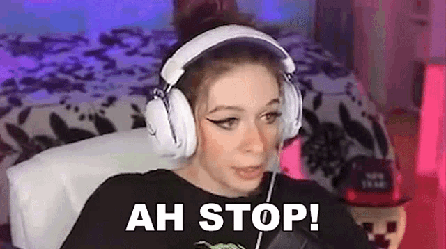 a woman wearing headphones is sitting in a chair and making a funny face .