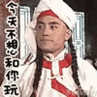 a man wearing a chef 's hat and tie with chinese writing on it .