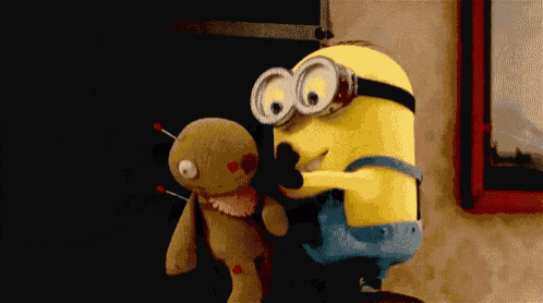 a yellow minion is holding a stuffed animal with a picture in the background