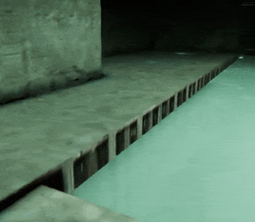 a swimming pool with a row of bricks on the side of it