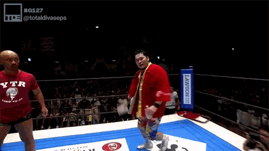 a man in a red jacket is holding up a card that says no.1
