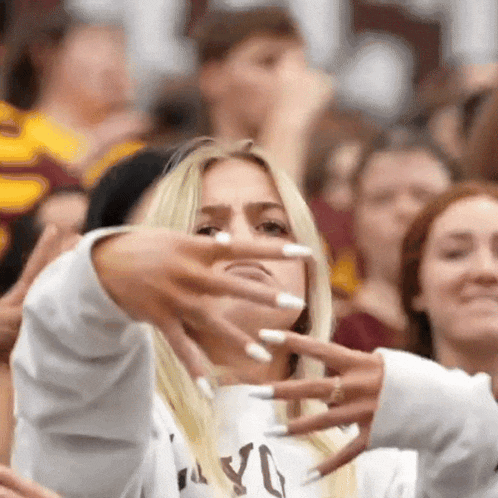 a woman with long white nails is making a funny face with her hands