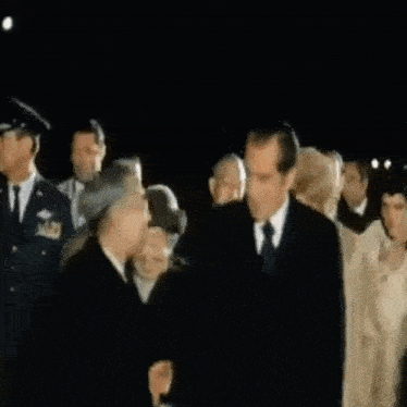 a man in a suit is shaking hands with a woman