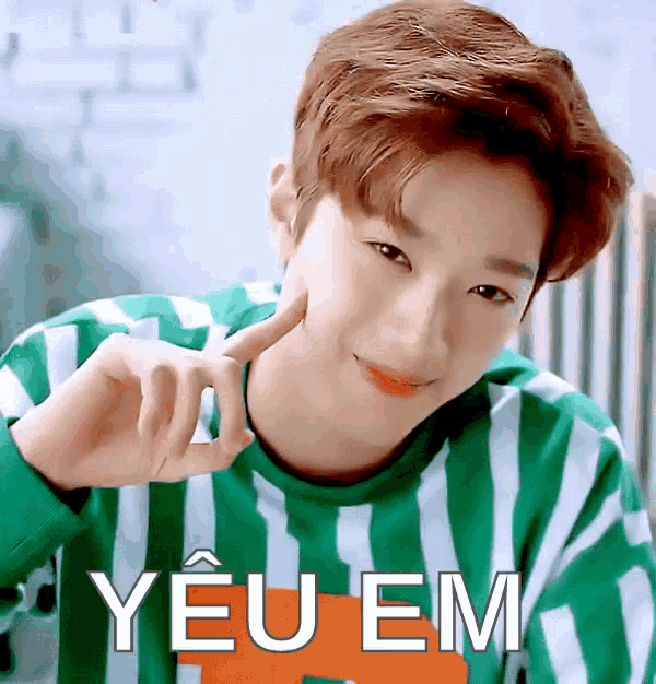 a young man wearing a green and white striped shirt with the word yeu em written on the bottom