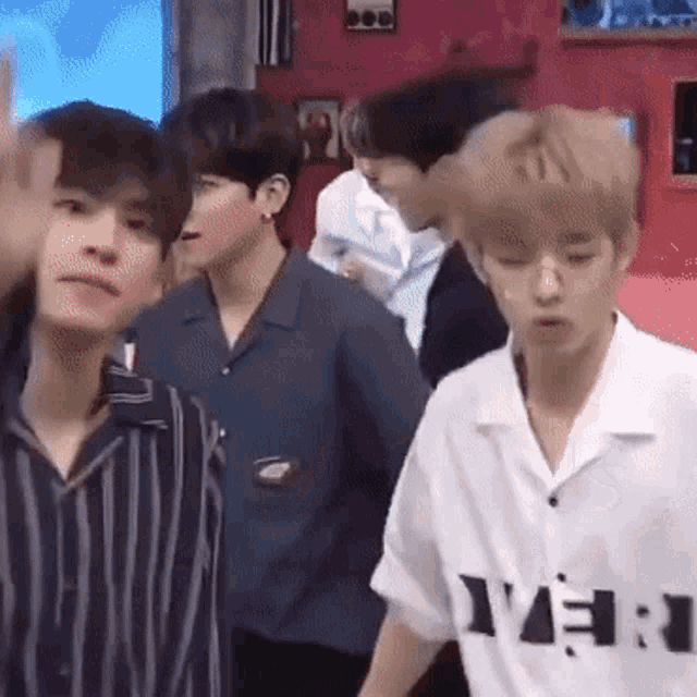 a group of young men are standing next to each other and one of them is wearing a shirt that says y.e.i.