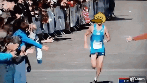 a runner with a duck on his head is being greeted by a crowd .
