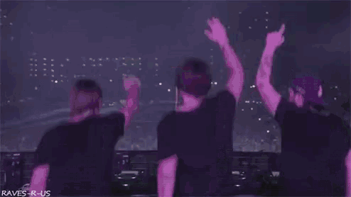 a group of people are dancing on a stage with their arms in the air .