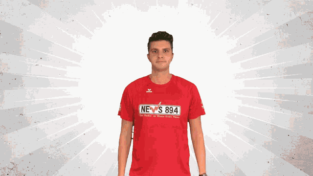 a man wearing a red t-shirt that says news 894