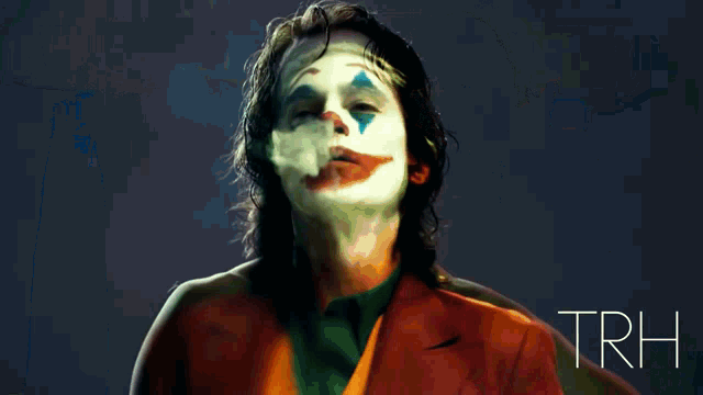 a man in a joker costume is smoking a cigarette in a hallway