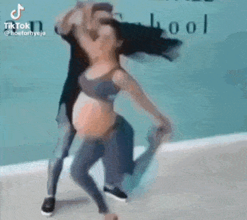 a man is holding a woman in his arms while they are dancing .
