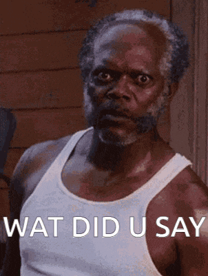 a man with a beard wearing a white tank top says " wat did u say "