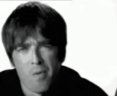 a black and white photo of a man making a funny face with his hand on his chin .