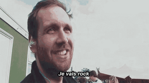 a man with a beard is smiling and talking in french .