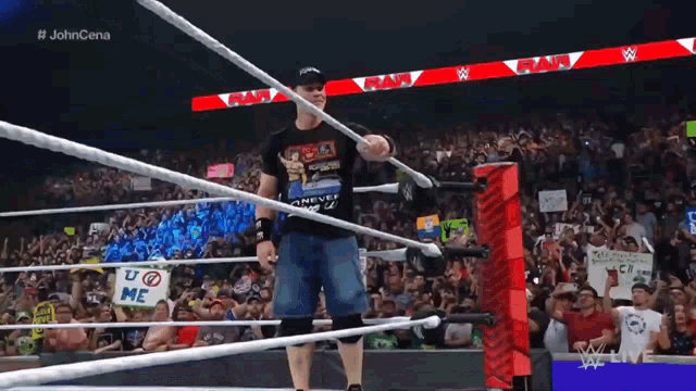 a man in a shirt that says " never give up " is standing in a wrestling ring