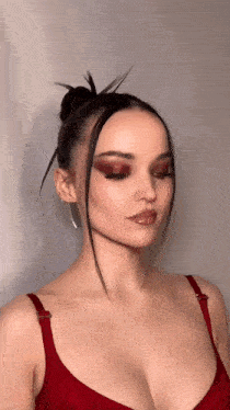 a close up of a woman 's face wearing a red bra and earrings .