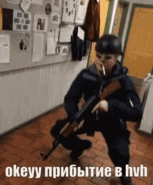 a man is kneeling down with a gun and smoking a cigarette in a hallway .