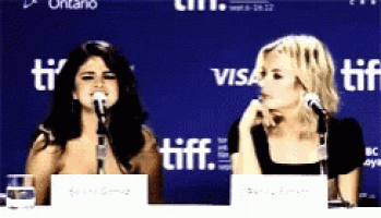 two women are sitting at a table with microphones in front of a sign that says tiff