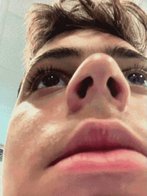 a close up of a man 's face with his eyes looking up