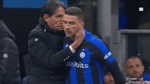 a soccer player wearing a digitalbits jersey is being comforted by another player
