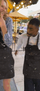 a man in an apron is standing next to a woman in a plaid shirt