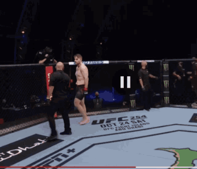 a man without a shirt is standing in a boxing ring .