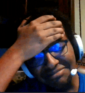 a man wearing headphones and glasses is covering his face with his hand