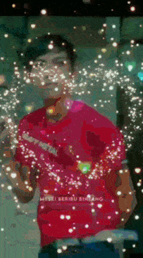 a man in a red shirt is surrounded by sparklers and the words ' meski beribu bintang ' on the bottom