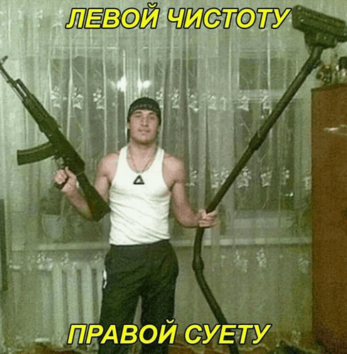 a man in a white tank top holds two guns and a vacuum cleaner in his hands