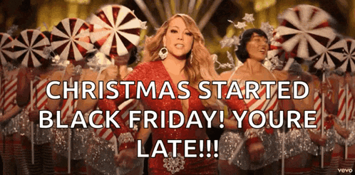 a woman in a red dress is dancing in front of candy canes and says christmas started black friday youre late